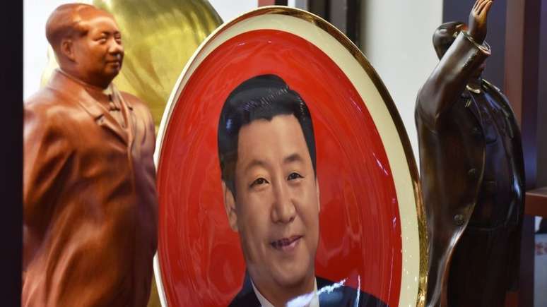 Decorações com o rosto de Mao e Xi Jinping; ele também enfrenta problemas internos