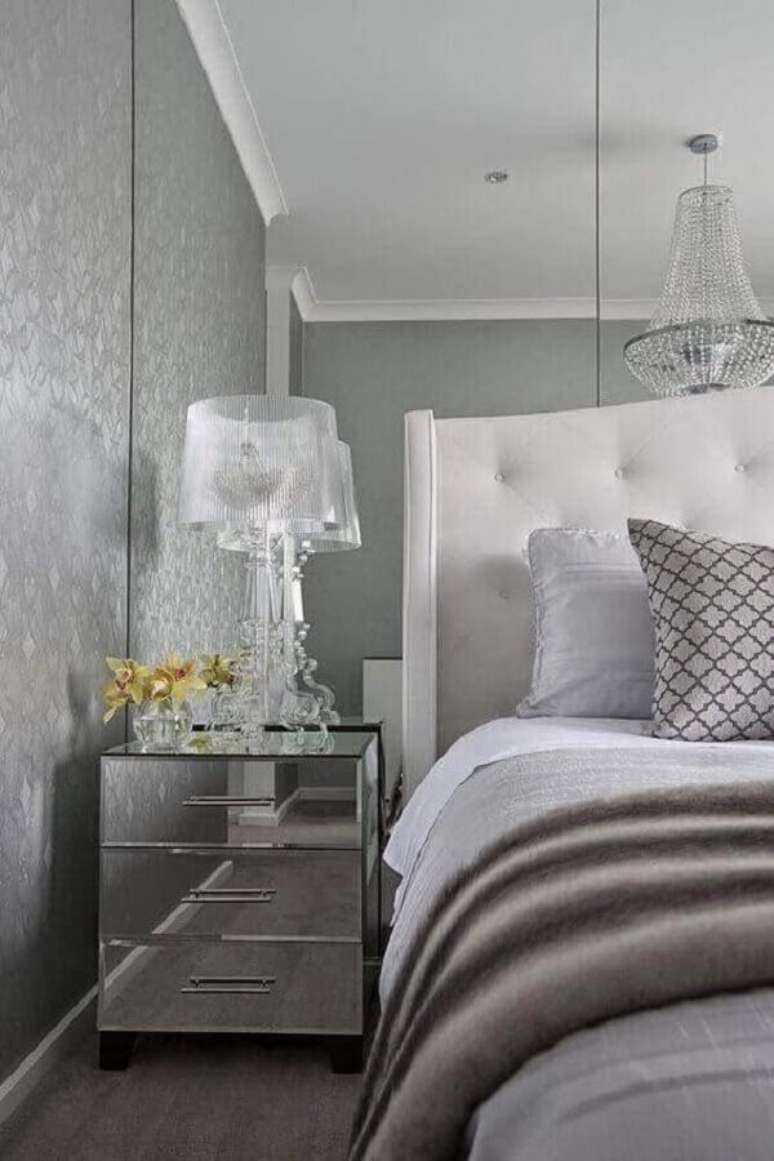 64. Sofisticado abajur para quarto moderno decorado com criado mudo espelhado e papel de parede cinza – Foto: Decorpad