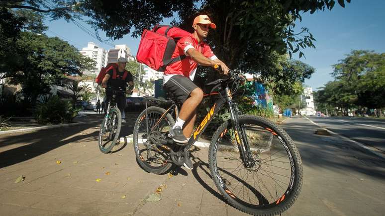 Os entregadores Robert dos Santos, 23, e Gabriel de Jesus, 22, trabalhando em Pinheiros, zona oeste de São Paulo