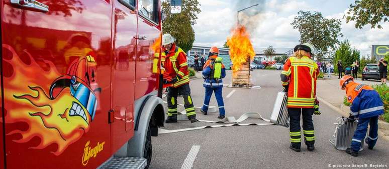 Membros do corpo de bombeiros executam uma demonstração de combate ao fogo num estacionamento na Alemanha