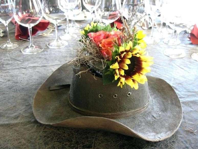 15. Uma decoração de festa junina muito legal é utilizar o chapéu com flores para enfeitar a mesa.