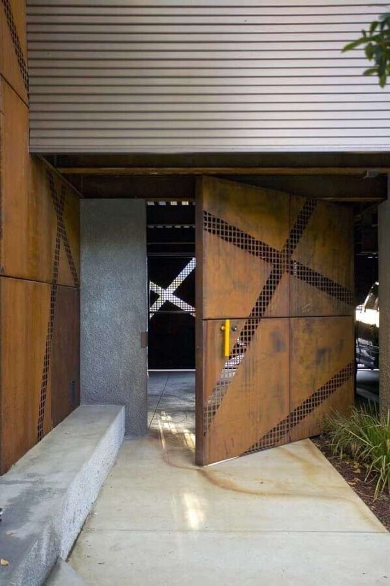 44. Fachada moderna com porta pivotante em aço corten e puxador amarelo ganhando destaque – Foto: Blue Ridge Apartments