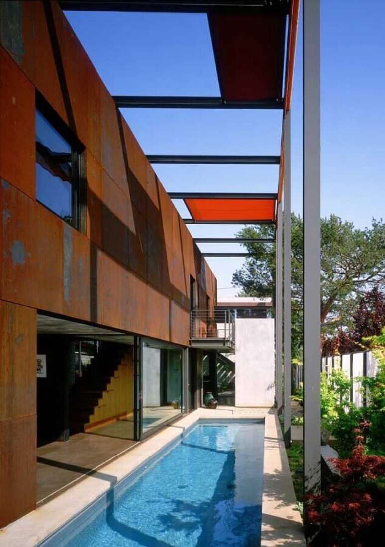 46. O revestimento aço corten deu um toque especial a essa fachada com piscina – Foto: Design Builders