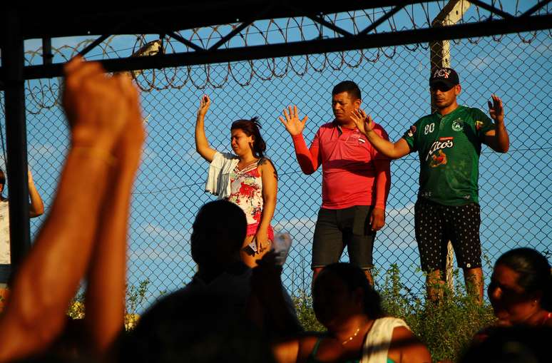 Familiares de detentos fazem oração em frente ao presídio