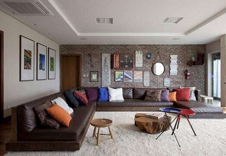 31. Aqui, vemos o sofá marrom com almofadas multicoloridas. Projeto de Juliana Pippi