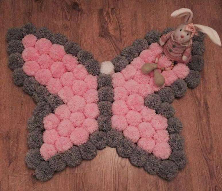 28. Como fazer tapete de pompom com formato de borboleta rosa e cinza. Fonte: Pinterest