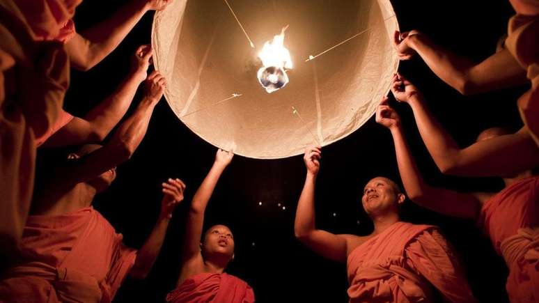 Monges budistas lan&ccedil;am lanternas ao c&eacute;u durante o festival Yee Peng em Chiang Mai. O ritual simboliza a libera&ccedil;&atilde;o de bondade e benevol&ecirc;ncia