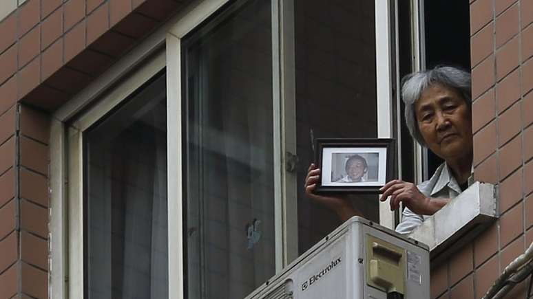 Zhang Xianling mostra a jornalistas em 2014 uma foto do filho, vítima da repressão aos protestos