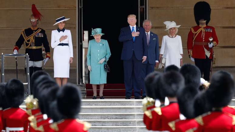 Donald Trump e a rainha Elizabeth Segunda ouvem o hino americano, parte da cerim&ocirc;nia de recep&ccedil;&atilde;o no Pal&aacute;cio de Buckingham