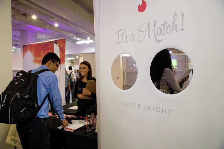 Pessoas conversam em frente a estande do Tinder, durante feira TechFair em Los Angeles. 8/3/2018. REUTERS/Monica Almeida 