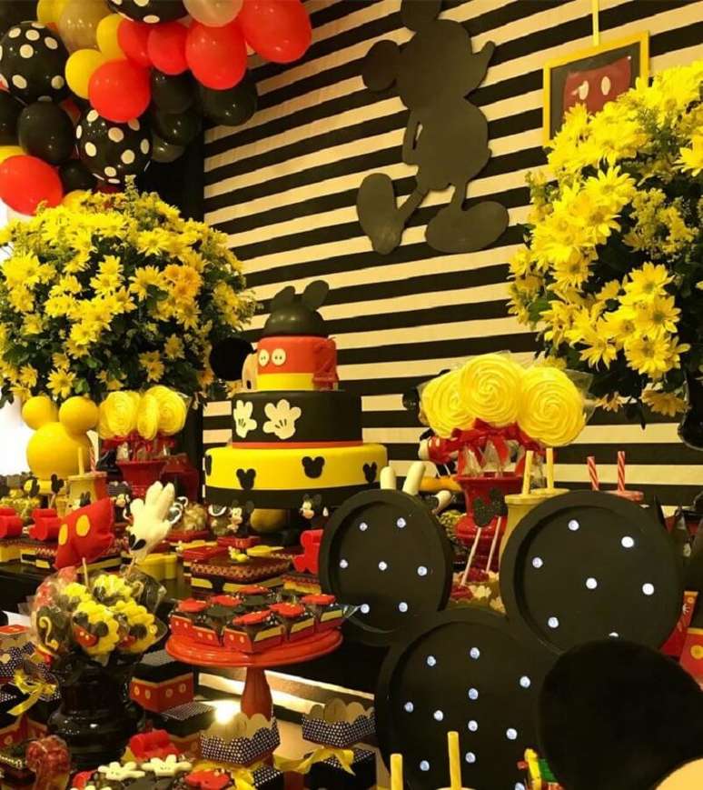 73. Decoração de festa do Mickey Mouse em tons de amarelo, vermelho, preto e branco e com arranjo de flores – Foto: Jacke Sales