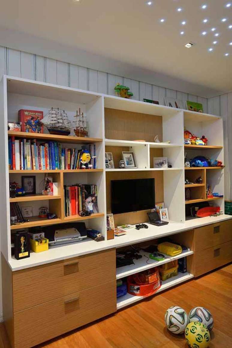 10- O quarto infantil planejado com estante de prateleiras e gavetas acomodam os brinquedos, televisão e objetos decorativos. Fonte: Marlon Gama