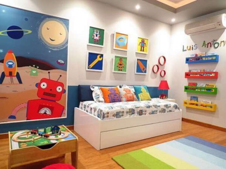 38- O quarto infantil planejado tem prateleiras coloridas na parede para acomodar os livros. Fonte: Pinterest