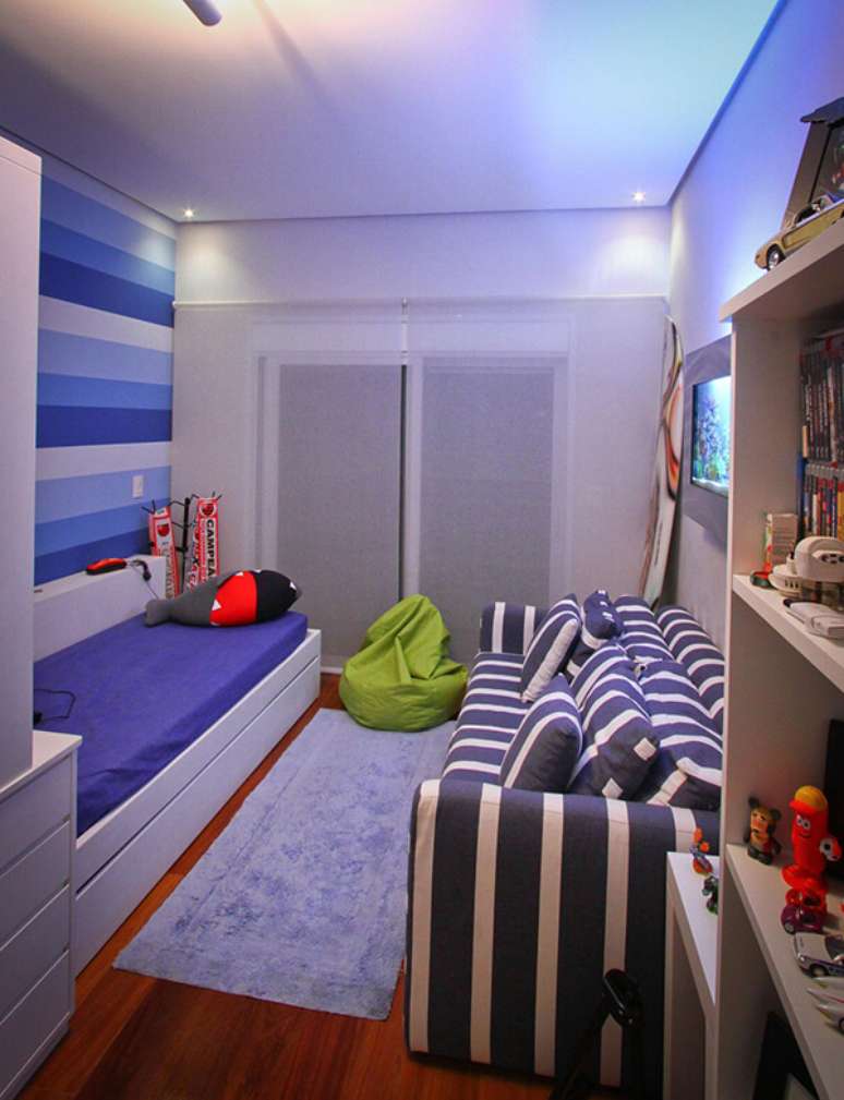 59- O quarto infantil planejado tem estante de livros, gaveteiros e bicama no mesmo tom de madeira. Fonte: Lilian Morel