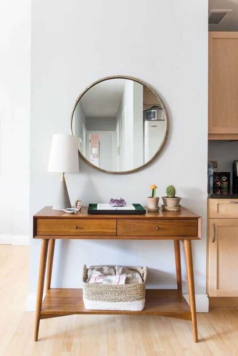 17. Decoração com aparador retrô de madeira e espelho redondo – Foto: Blue Ridge Apartments