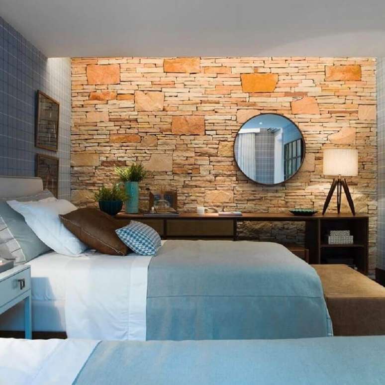 29. Decora&ccedil;&atilde;o para quarto com parede de pedra e espelho redondo &ndash; Foto: Studio FN