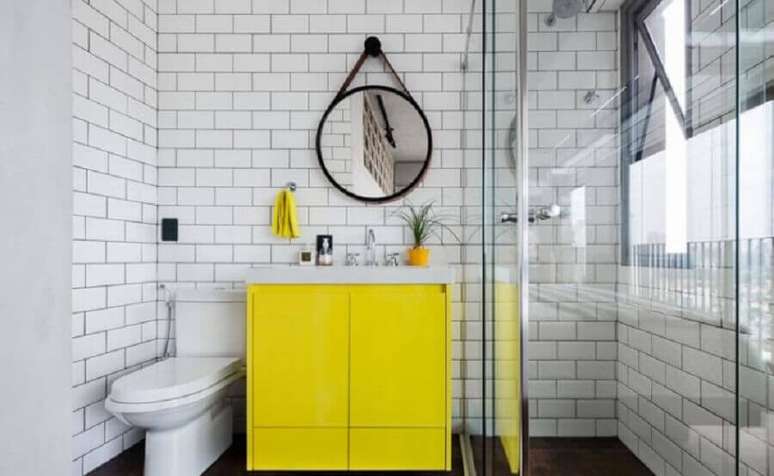 39. Espelho redondo com al&ccedil;a para decora&ccedil;&atilde;o de banheiro moderno com subway tile e gabinete amarelo &ndash; Foto: Marcela Madureira