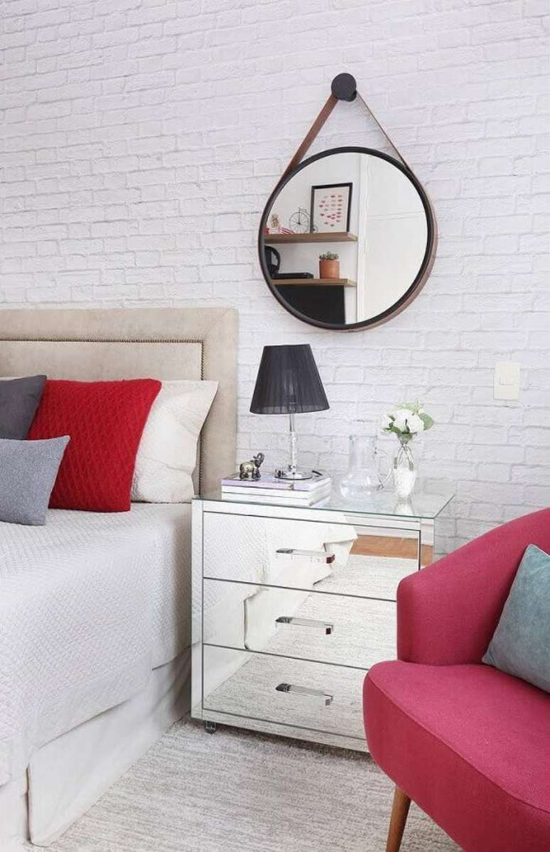 41. Espelho redondo com alça para decoração de quarto todo branco com poltrona rosa e criado mudo espelhado – Foto: Duda Senna