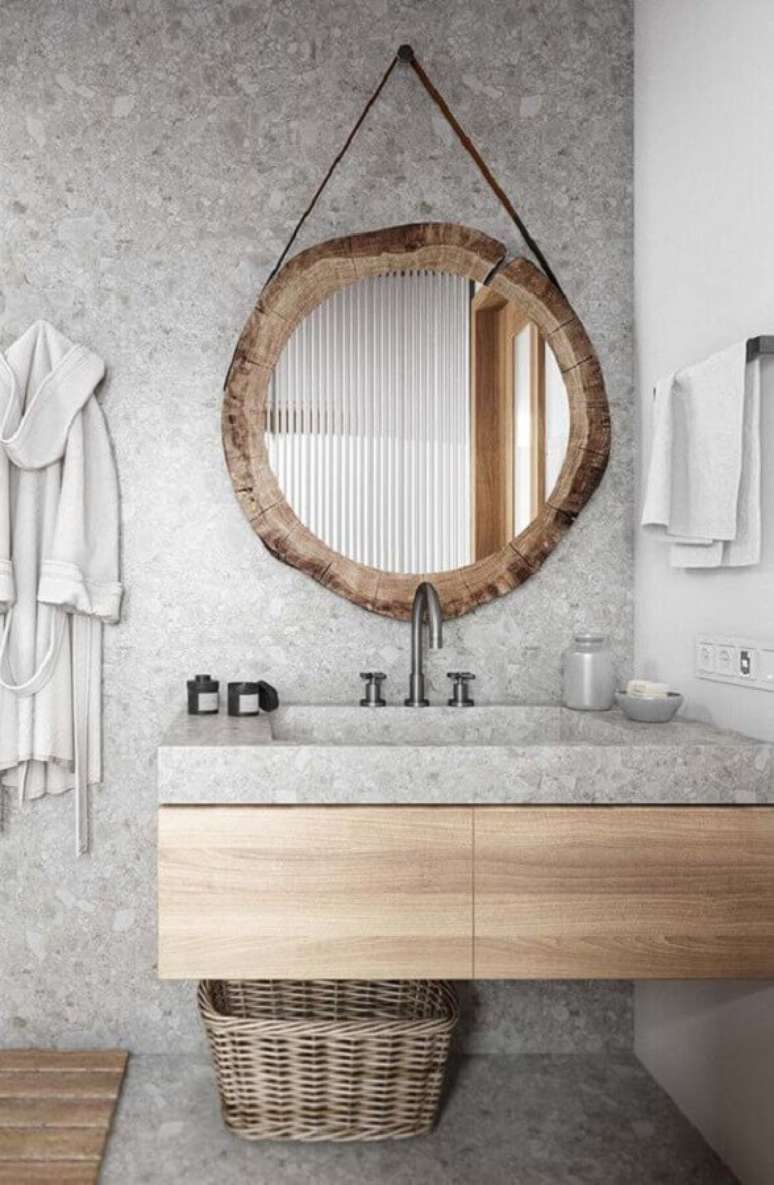 49. O espelho redondo com moldura rústica se tornou o grande destaque na decoração do banheiro cinza – Foto: Cavalus