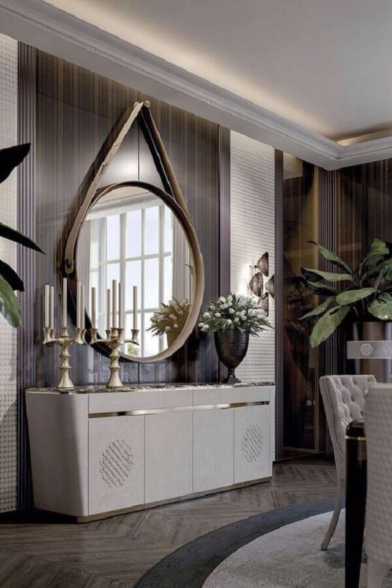 50. Espelho redondo grande com alça de couro para decoração sofisticada – Foto: Vittoria Frigerio