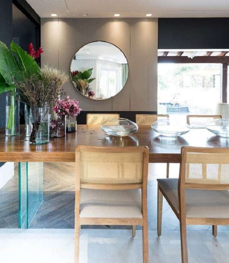 59. Sala de jantar sofisticada decorada com espelho redondo e mesa de madeira – Foto: Lucas Barbosa