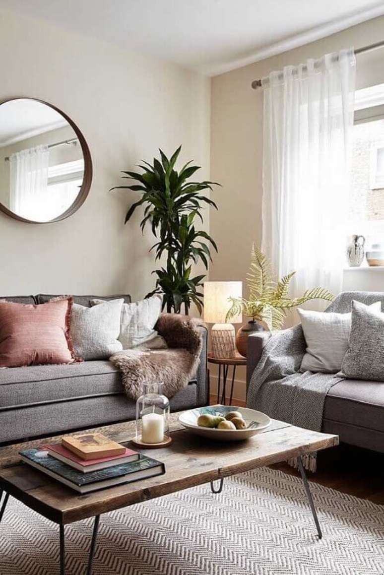 61. Espelho redondo para sala decorada com muitas almofadas e sofá cinza – Foto: Pinterest