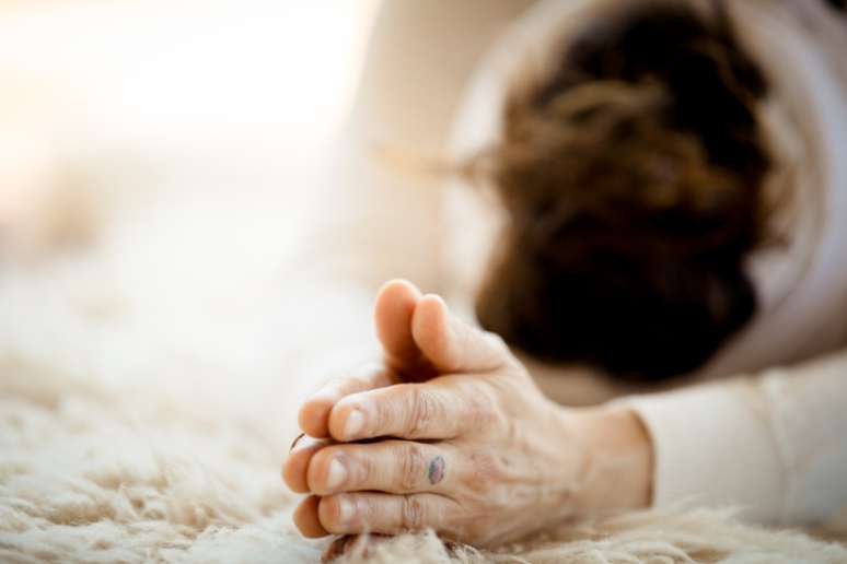 Mulher praticando a sauda&ccedil;&atilde;o de Kundalini yoga e sol 