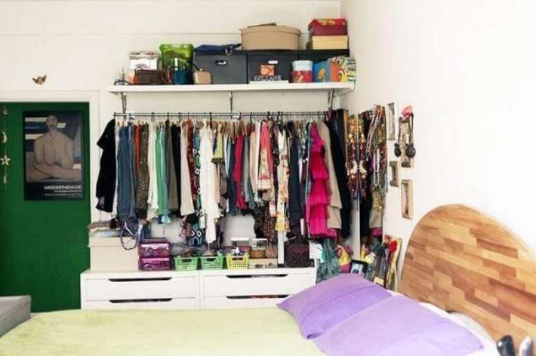 37. O closet aramado pode ser usado para complementar as cômodas de madeira no quarto.