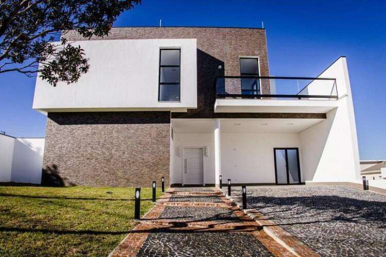 40. Fachada que contrasta cores escuras com o branco. Projeto por Haus Arquitetura