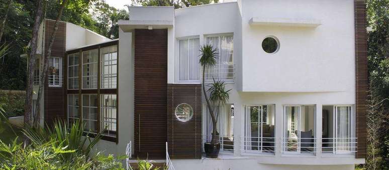 42. Casa bonita com grandes janelas e revestimento de madeira. Projeto por Olegário de Sá e Gilberto Cioni