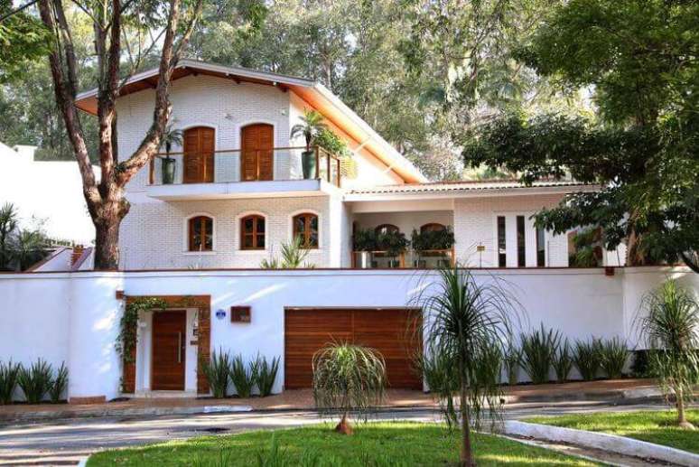 30. Casa bonita, toda branca e com portas, portões e janelas em madeira. Projeto por Meyer Cortez