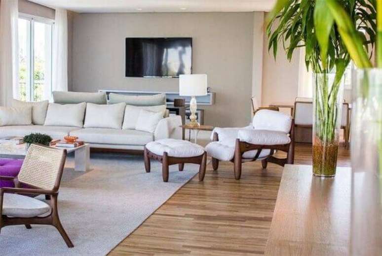 13. Poltrona branca mole complementa a decoração da sala de estar. Projeto de Renata Florenzano