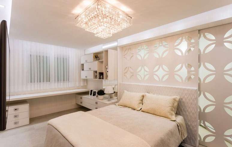 54. Decoração em tons neutros com lustre de cristal para quarto de casal – Foto: Webcomunica