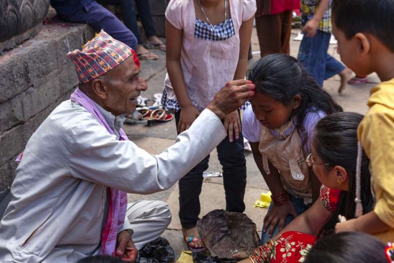 Profeta Nepal e mulheres vestidas roupas tradicionais vermelha no evento religioso no templo