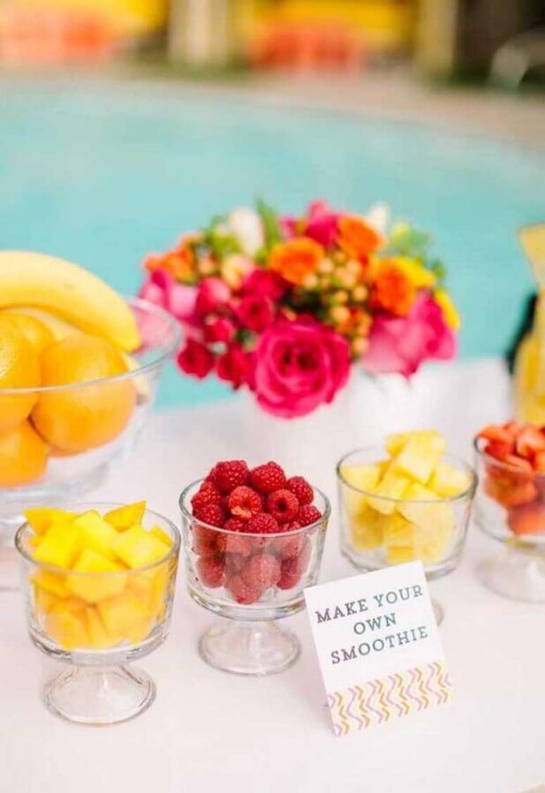 64. Mesa de doces e comidas para festa na piscina decorada com flores – Foto: Bacuri Festas