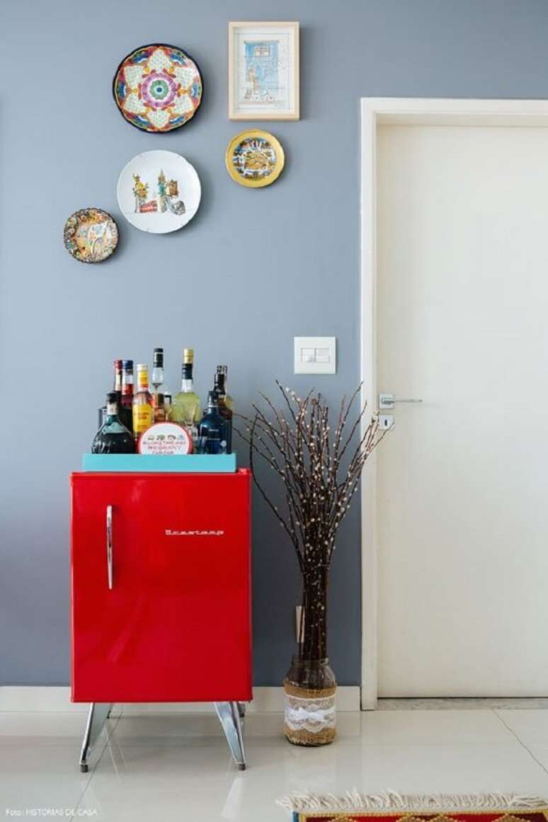 17. Mini geladeira vermelha serve de base para as bebidas. Fonte: Histórias de Casa