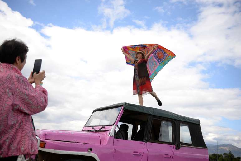 Mulher posa para foto com len&ccedil;o no topo de carro pr&oacute;ximo a Lago Erhai, na China
15/06/2016
REUTERS/Tingshu Wang