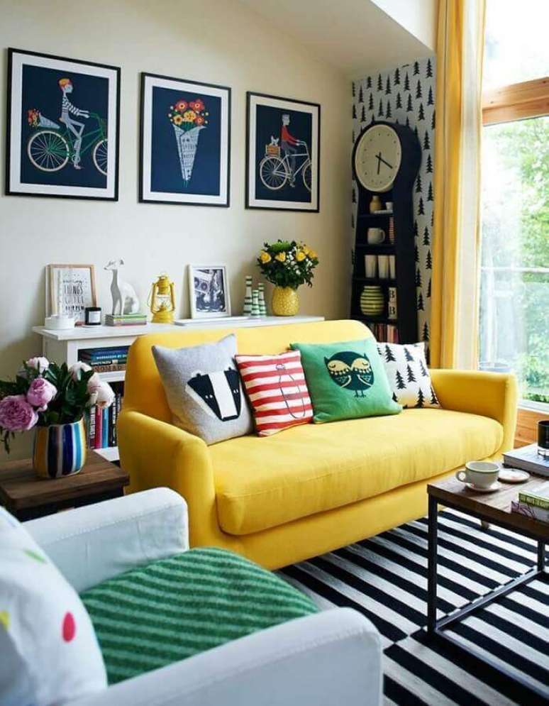 36. Decoração para sala com tapete preto e branco listrado e capas de almofadas coloridas para sofá amarelo – Foto: Dani Guedes