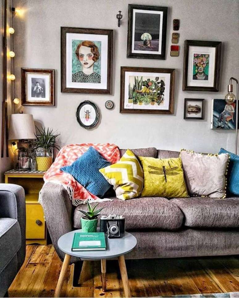 52. Sala decorada com vários quadros e almofadas coloridas para sofá cinza – Foto: DIYCores