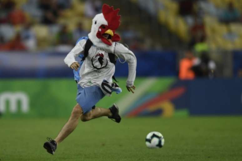 Torcedor invadiu o gramado com uma "cabeça" de galo Mauro PIMENTEL / AFP