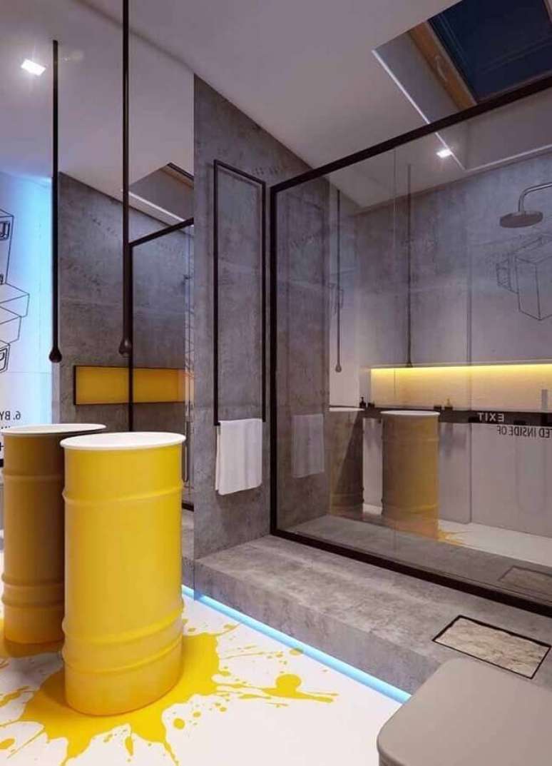 12. Banheiro moderno decorado com cimento queimado e tonel decorativo amarelo – Foto: Pinosy