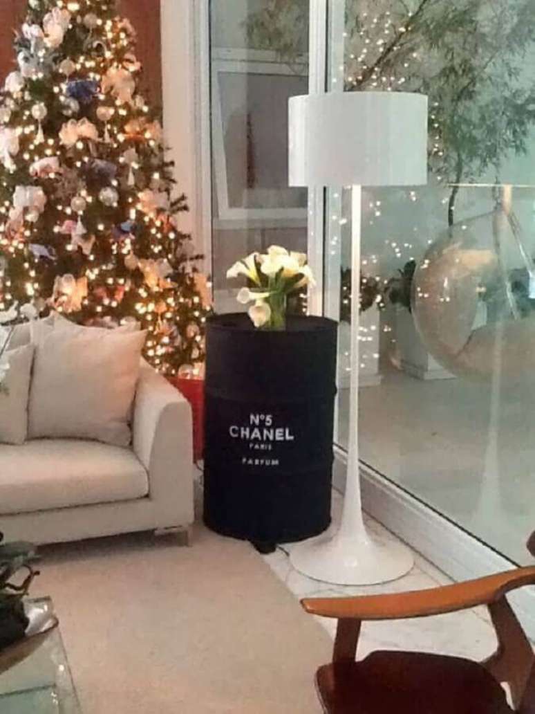 29. Sala decorada com árvore de natal e tonel decorativo preto com logo da Chanel – Foto: Casa com Moda