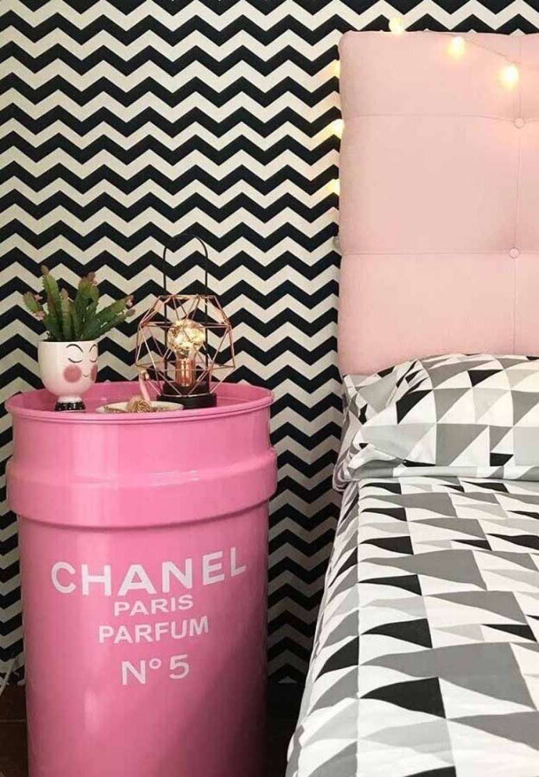 33. Decoração de quarto feminino com papel de parede preto e branco e tonel decorativo rosa com logo da Chanel – Foto: Zozu