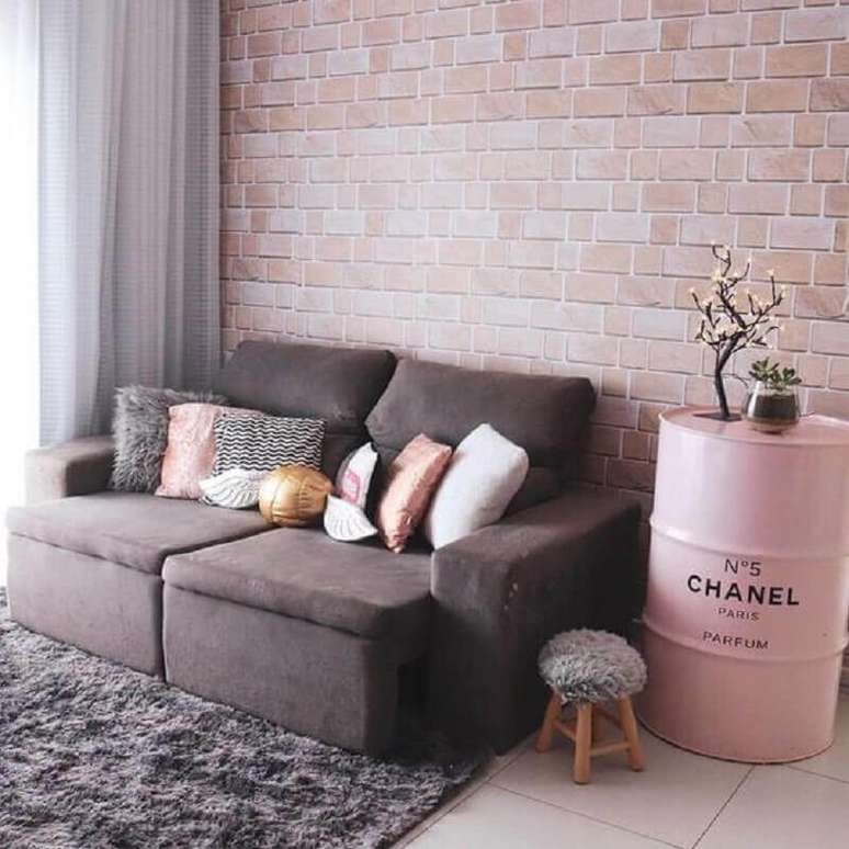 43. Sala de estar decorada com parede de tijolinho e tonel decorativo rosa com logo da Chanel – Foto: We Heart It