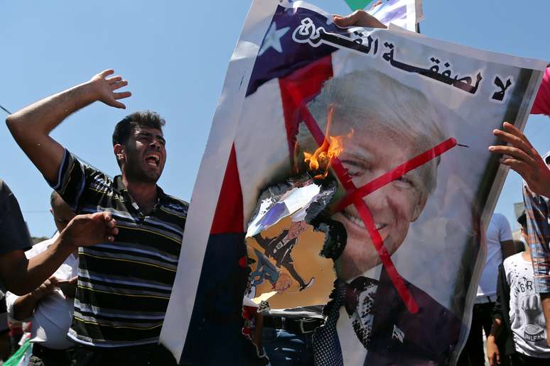 Manifestantes palestinos queimam retrato do presidente dos EUA, Donald Trump, durante protesto na Faixa de Gaza