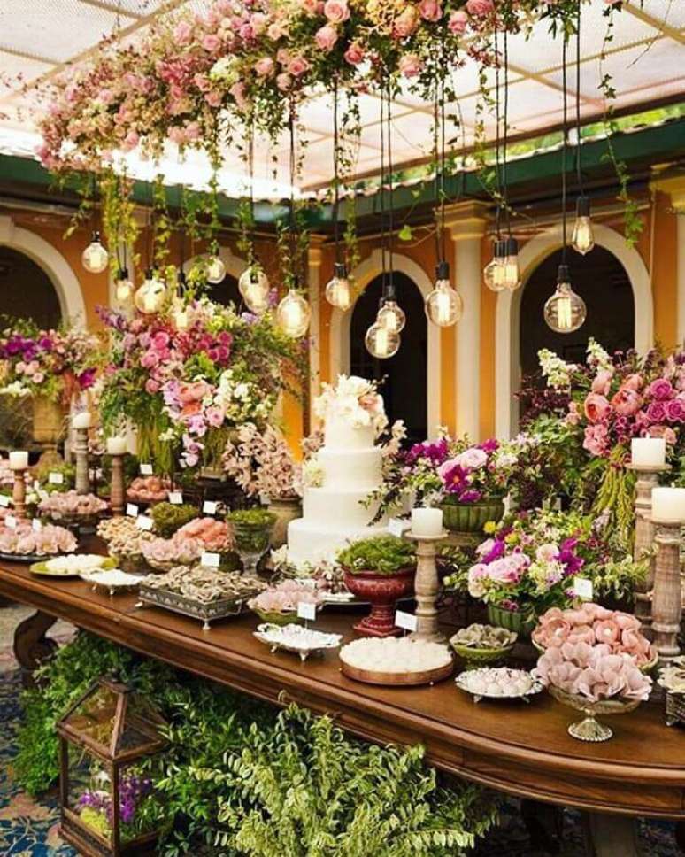 71. Linda mesa de bodas de casamento decorada com muitas rosas e luminárias minimalistas – Foto: Why Santa Claus