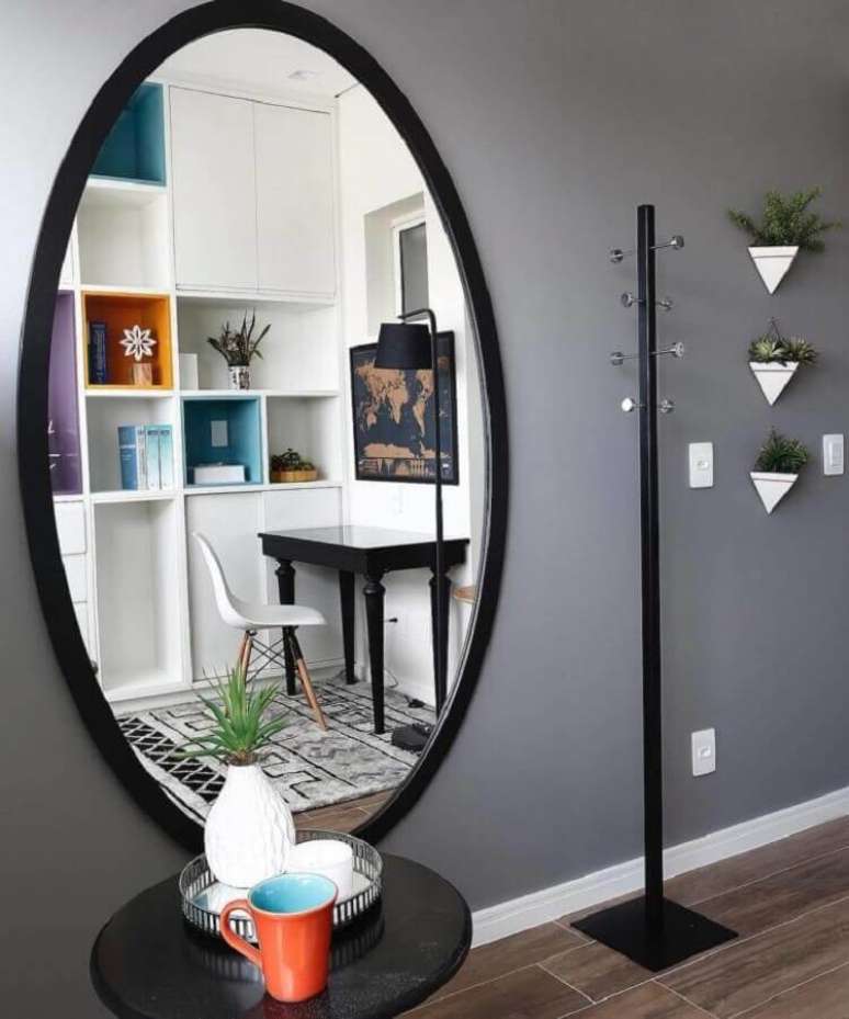 16. Cabideiro de chão com design minimalista para decorar o hall com espelho redondo grande – Foto: Inside Arquitetura & Design