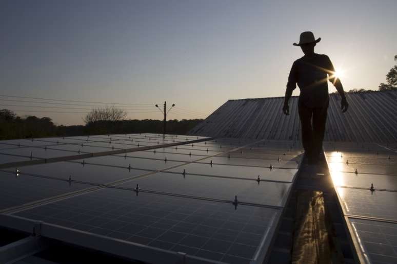 Homem caminha entre pain&eacute;is para capta&ccedil;&atilde;o de energia solar em Vila Nova do Aman&atilde; (AM) 
22/09/2015
REUTERS/Bruno Kelly