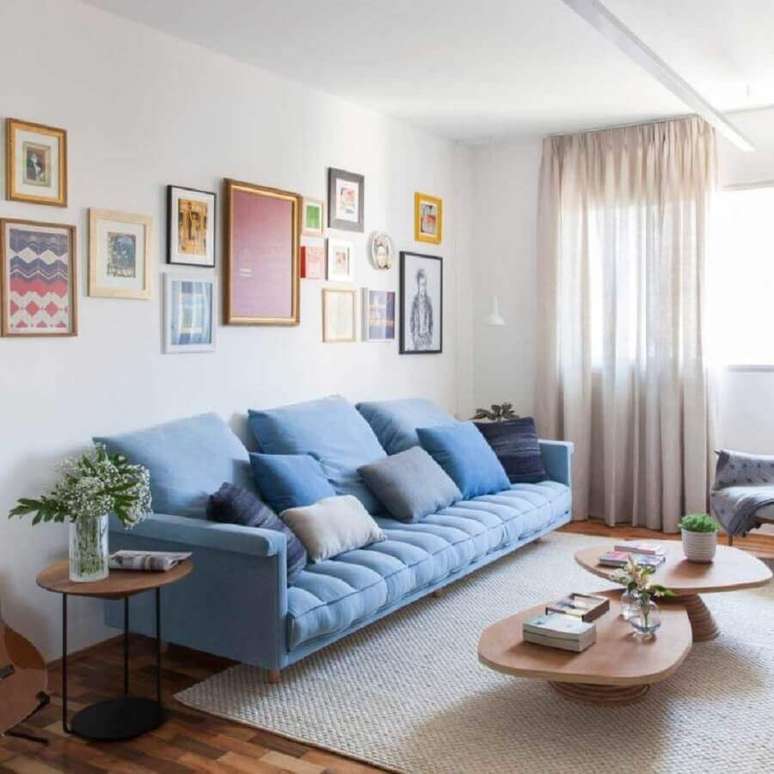 16. Decoração clean para sala com mesa de centro de madeira e sofá azul claro – Foto: Iná Arquitetura