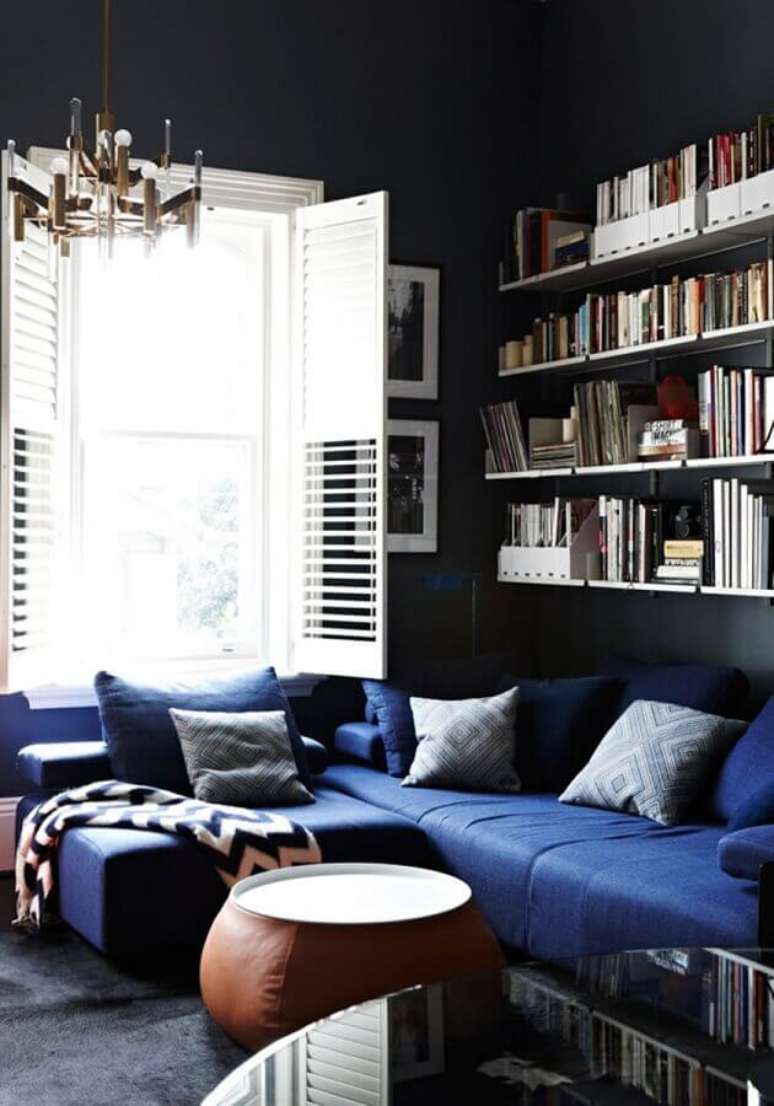 9. Decoração para ambiente com sofá de canto azul escuro com prateleiras de livros – Foto: Yandex